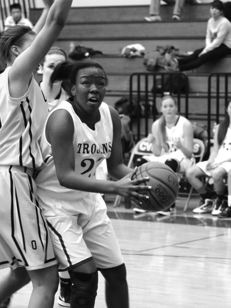 Asia Robinson looks up at the basket to take a shot as teammates cheer from the sidelines.